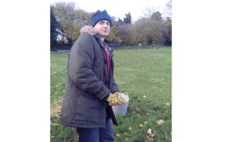 photo of K in field with hat on smiling